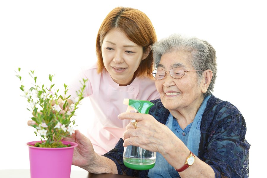 Smiling old woman with plant isolated on white background